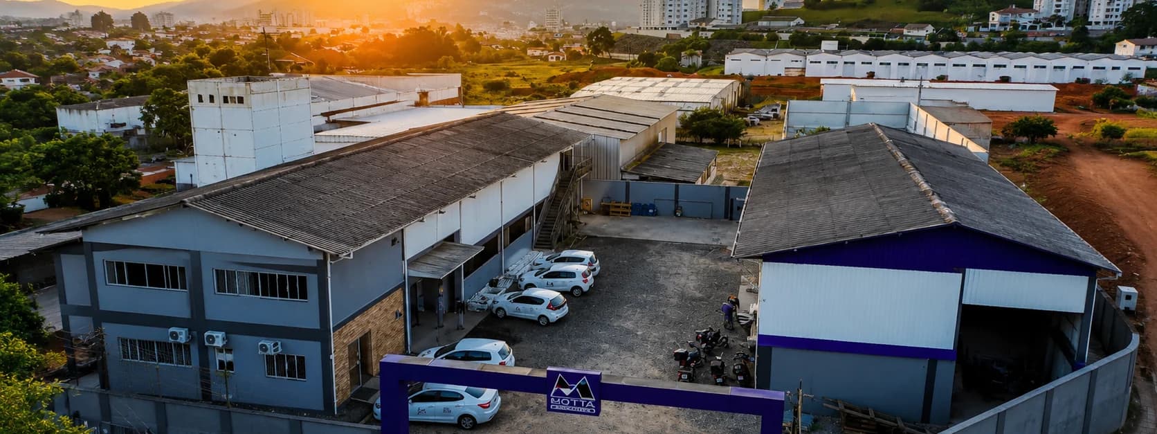 Vista aérea da sede da Motta Elevadores em Camboriú ao entardecer